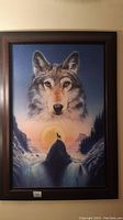 Front view of the large framed wolf picture showing the wolf head and howling wolf at sunset scenery