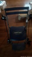 Front view of the Chair Gym showing padded seat, frame, and resistance bands with handles on each side