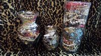 Three glass jars filled with assorted vintage jewelry items placed against leopard print fabric.
