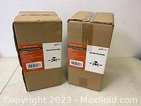 Two unopened boxes of Sputnik ceiling light fixtures placed side by side on a table.