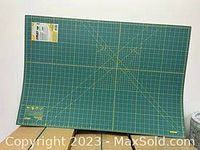 Full view of the green OLFA cutting mat with yellow grid lines and angle guides.