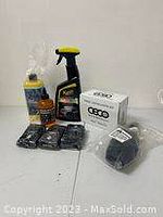 Photo of Meguiar's spray bottle, cleaning liquids, ECO Vehicle Ventilation Kit box, and black cleaning brushes on white background.