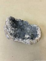 Top angled view of celestite geode showing blue crystal clusters inside the natural rock matrix.