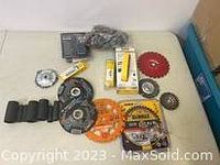 Overview of yellow cordless drill, saw blades, drill bits, battery packs and accessories arranged on a white surface