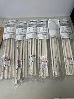 Six sets of new Blum drawer sliders packaged individually in plastic, laid out in a row showing packaging and labels.