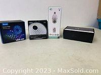 Four boxed items on table including two LED strip light boxes and two other boxes possibly containing LED accessories or controllers.