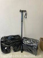 Photo showing one blue foldable cane and two packaged black Dr. Pillows back/neck pillows arranged against a white wall.