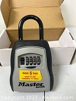 Master Lock combination padlock in packaging showing 5 key holder sticker on front.