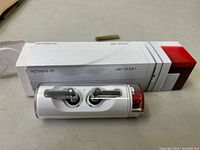 Photo of white box labeled Nothing (R) Ear (1) with the wireless earsticks and charging case displayed in front.