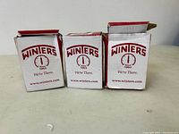 Three Winters branded boxes for pressure gauges, unopened or slightly opened, showing brand and website details.