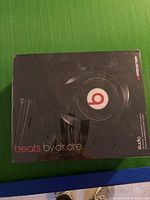 Front of sealed black box with large red and white Beats “b” logo and “beats.by.dr.dre” text