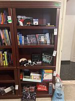 Front and side views of the wood veneer bookcase with various items on shelves to show scale and shelf spacing.
