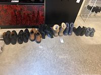Photo showing all boots lined up on the floor including black leather, tan, and various casual styles
