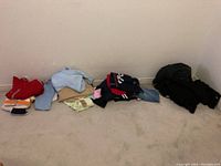 Folded various pants and shirts in multiple colors laid out on floor