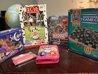 Six Disney and Marvel themed items displayed on table including Sailor Moon Moon Cycle, 101 Dalmatians sprinkler, Marvel Trivia Game, Castle Classics 7 game centre, Disney Princess pencil case, and Hello Kitty picture frame.