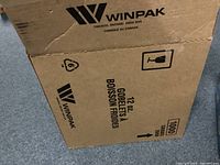 Cardboard box labeled Winpak, Toronto Ontario, with markings indicating 12 oz goblets, total 1000 units