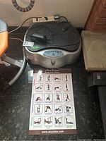 Full view of exercise machine on floor next to chair and couch with exercise chart placed in front