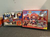 Photo showing boxed Mega Bloks Western Cactus Town playset next to boxed remote controlled fighting robots.