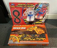 Two boxed toys side by side: the Power Chase electric racetrack and the Matchbox Mega-Rig trucks.