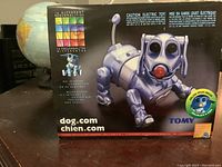 Front view of the boxed Tomy Robot Dog showing product name, features like 16 different personalities.