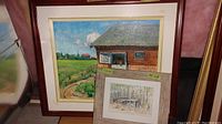 Photo showing the large framed painting of horse stable with visible horse and surrounding landscape, along with the smaller painting placed in front.