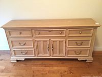 Front view of the large wooden dresser showing seven drawers and two central doors.