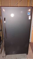 Front exterior view of gray upright freezer