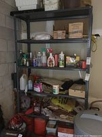 Full frontal view of the metal shelving showing four shelves with various items placed on them.