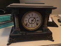 Front view of the full vintage Seth Thomas mantle clock showing the structure, decorative columns, and metal feet.