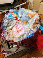 Large bag filled with multiple sealed Beanie Babies in plastic bags.