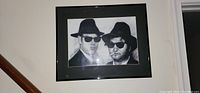 Front view of framed Blues Brothers picture, showing two men in hats and sunglasses in black and white.