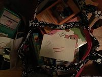 Image showing the Thirty One bag filled with numerous children's VHS tapes, with a note inside.