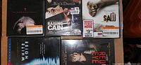 Five thriller DVDs arranged with visible cover art and price stickers.