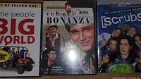 Photo showing three DVD cases: Little People Big World Season One, The Best of Bonanza Season 1, and Scrubs Complete First Season.