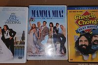 Three comedy DVD cases displaying 'My Big Fat Greek Wedding', 'Mamma Mia!', and 'Cheech and Chong: Next Movie' in clear view.