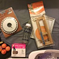 Photo shows LED dash light in packaging, wooden sock loom in packaging, plastic measuring bottle, knee highs box, and orange golf practice balls.