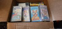 Box of VHS tapes showing four Arthur title tapes including 'Arthur's First Sleepover' and 'Arthur's Perfect Summer'