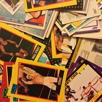 Close-up photo showing a pile of WCW wrestling cards featuring Sting and Wall Street with vibrant yellow and black borders.
