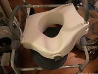 White XL air cast with padded seat and gray handles on a wooden floor indoor setting.