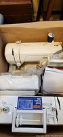 White Brother embroidery machine in box with large touch screen LCD visible, accessories in plastic bags