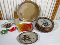 Collection of plates, bottle, shakers, napkin holder and bud vase shown on table