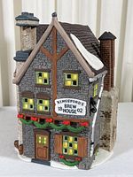 Front angled view of the Kingsford's Brew House porcelain model showing detailed brickwork, windows, door, roof with snow, and decorative garlands.