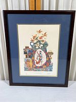 Framed lithograph showing full artwork and framing with dark wood frame and blue mat