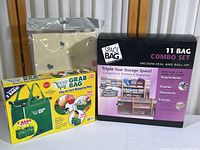 Photo shows the Space Bag 11-bag combo set black box, two green Grab Bags clip-to-cart shopping bags, and a new quilt storage bag in original packaging all displayed side by side