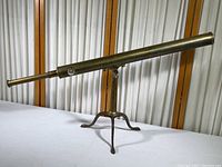 Full view of brass telescope mounted on three-leg folding tripod