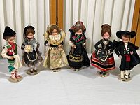 Wide view of all six vintage Spanish dolls by Beibi in varying traditional costumes, showing full body and detail of each doll.