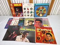 Photo showing all 11 Elvis Presley LP albums arranged on a white surface with covers visible including Burning Love, Christmas, Golden Records, and live session albums.
