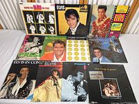 Top view of all 10 Elvis Presley albums with Ronnie McDowell album included, showing front covers and spines, laid out on white table surface.