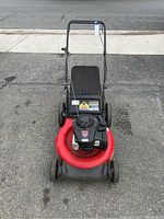 Overview of Yard Machines lawn mower showing red deck and black handle