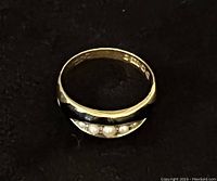 Top view of ring showing front design with four pearls and enamel inlay